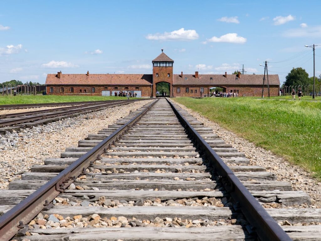 Bahngleise führen direkt auf das Torhaus des Konzentrationslagers ASymbol der Ankunft unzähliger Bahngleise mit Blick auf das Torhaus von Auschwitz-Birkenau, Mahnmal des Holocaust