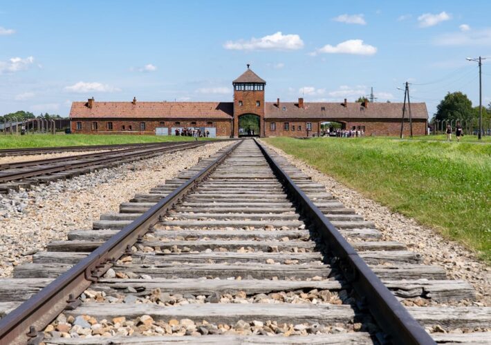 Bahngleise führen direkt auf das Torhaus des Konzentrationslagers ASymbol der Ankunft unzähliger Bahngleise mit Blick auf das Torhaus von Auschwitz-Birkenau, Mahnmal des Holocaust