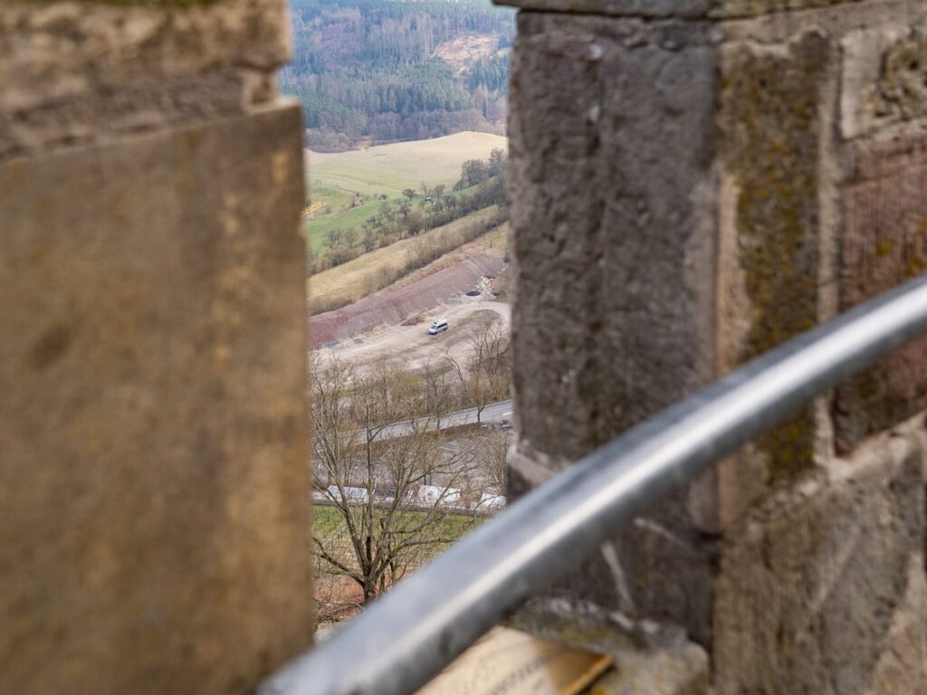 Auf dem Bergfried, Aussicht durch Zinnen ins Tal auf unseren Schlafplatz (Camper)