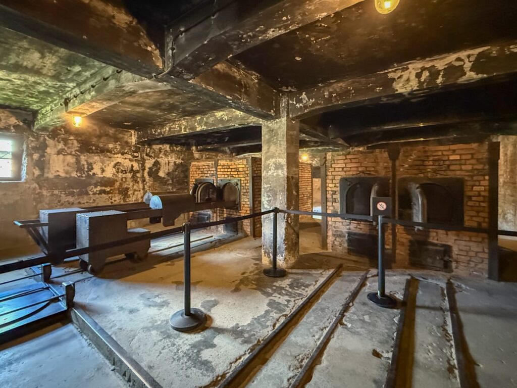 Innenansicht des Krematoriums in Auschwitz I mit Öfen und Schienen für Leichentransporte
