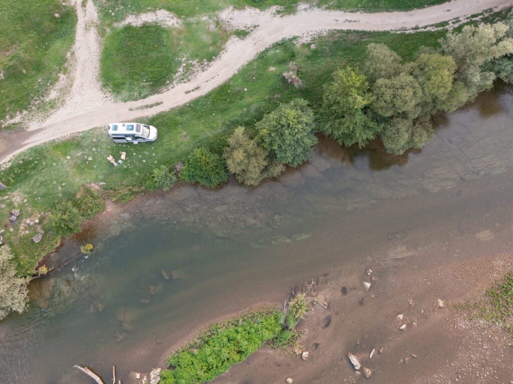 Luftaufnahme über dem Camper am Fluss Strei bei Bacia, mit deutlich sichtbarer Uferzone