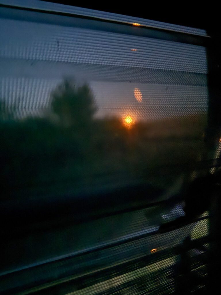 Blick durch das Heckfenster mit Fliegenschutz auf den Mondaufgang am Acumularea-Crestur-See.
