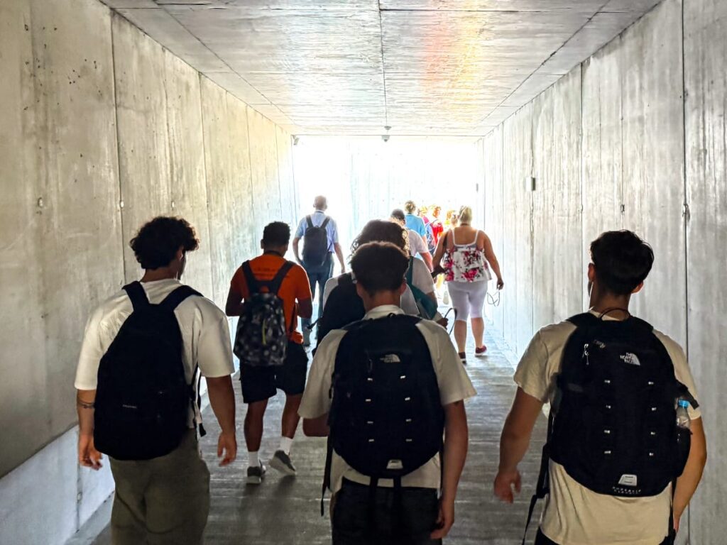 Besucher gehen durch den Tunnel zum Eingang des ehemaligen Konzentrationslagers Auschwitz