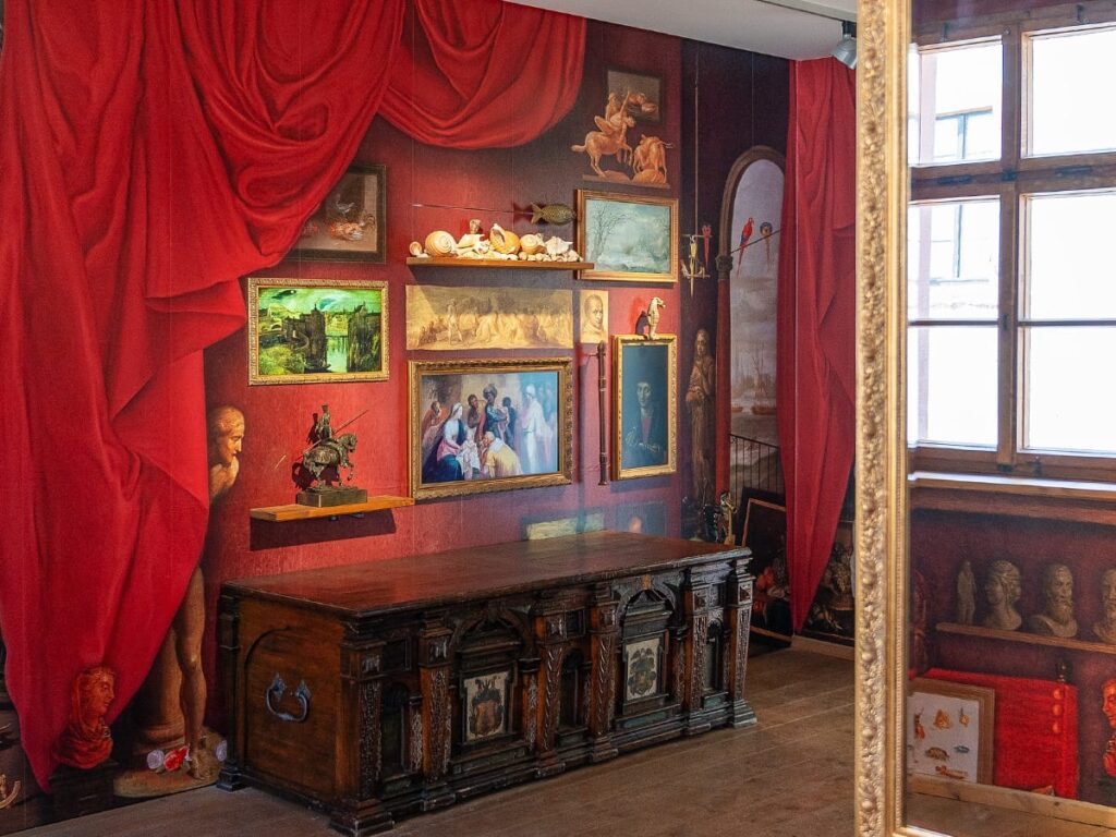Animierte Gemäldewand mit rotem Vorhang in der Porzellanausstellung auf der Leuchtenburg