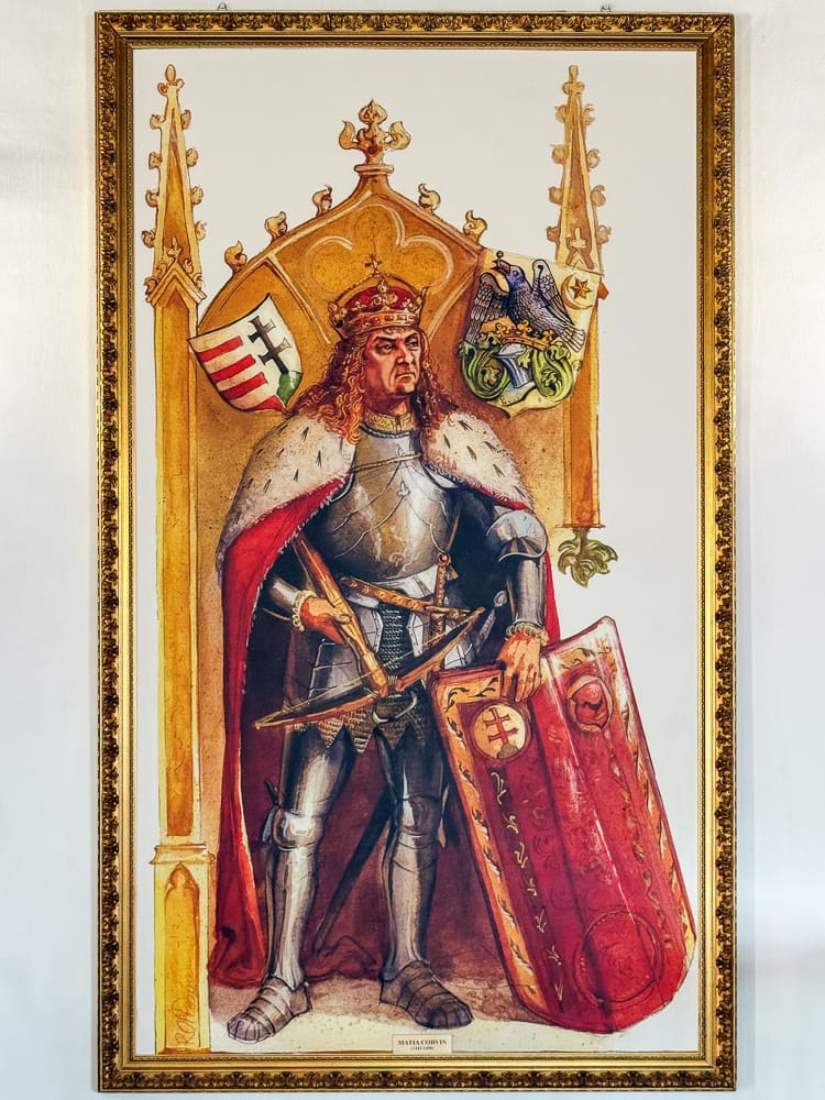 Gemaltes Porträt von Matthias Corvinus in Ritterrüstung mit Schwert und Schild in der Burg Corvin