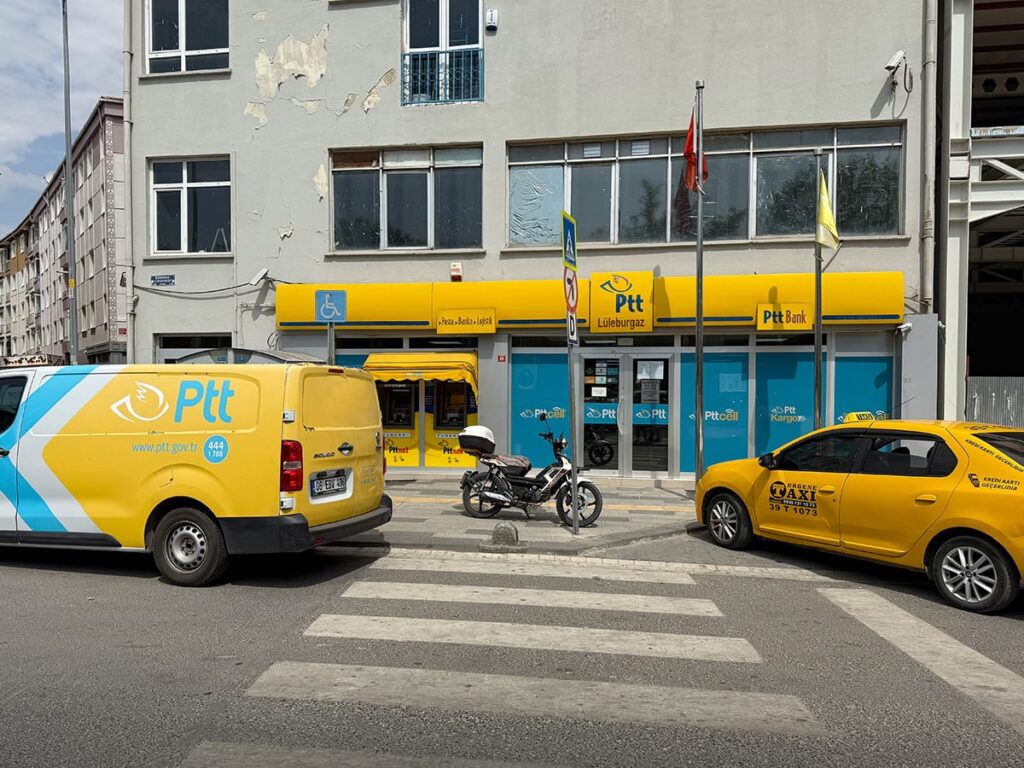 PTT-Filiale in Lüleburgaz mit gelbem Lieferwagen und Taxi davor