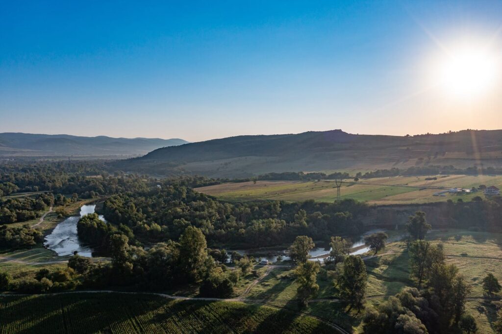 Sonnenaufgang über dem Strei-Fluss in Rumänien, idyllische Landschaft mit Hügeln und Feldern