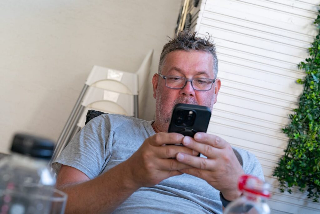 Mann mit Brille übersetzt am Smartphone die Speisekarte in einem rumänischen Restaurant