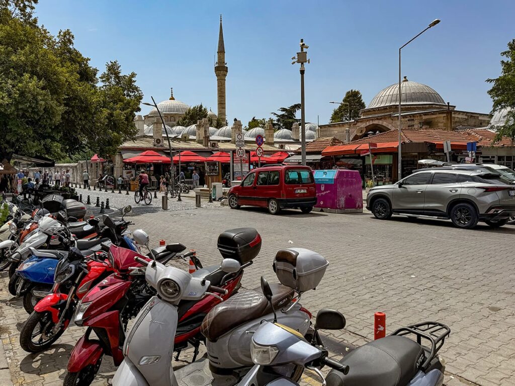 Straßenszene in Lüleburgaz mit Mopeds, Marktständen und Moschee im Hintergrund
