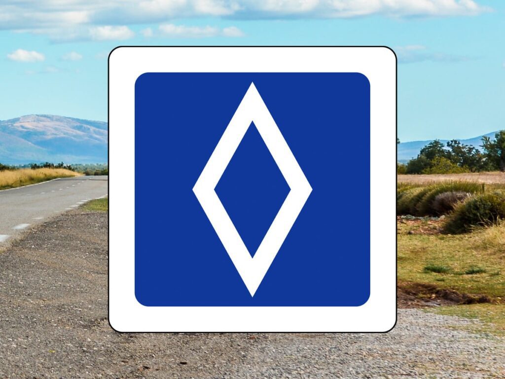 Französische Landstraße mit blauem Verkehrsschild und weißer Raute für Fahrgemeinschaften