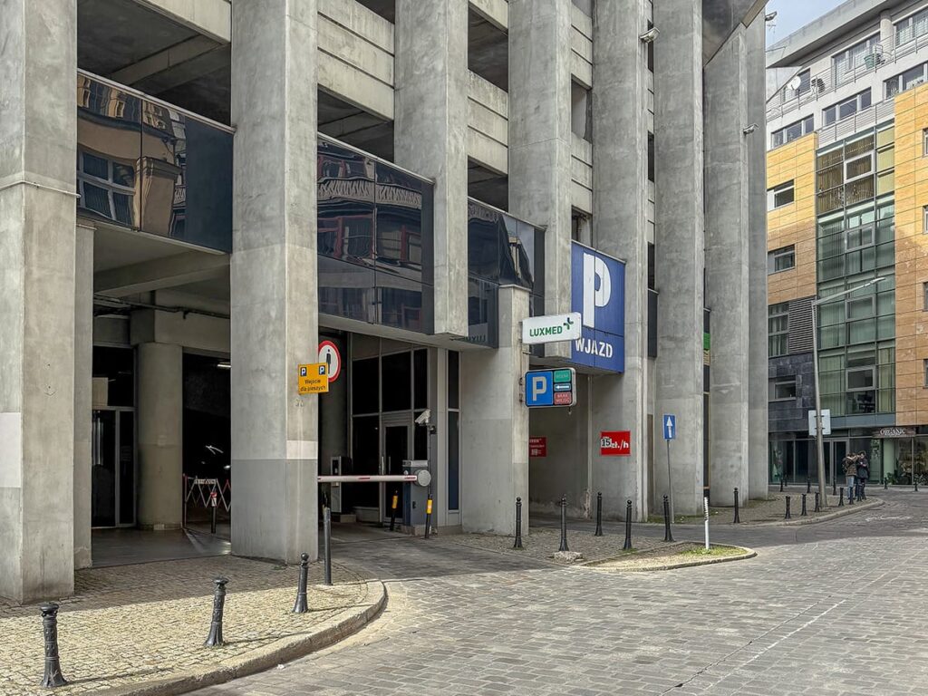 Einfahrt in ein Parkhaus im Zentrum von Breslau mit modernen Gebäuden und Betonpfeilern