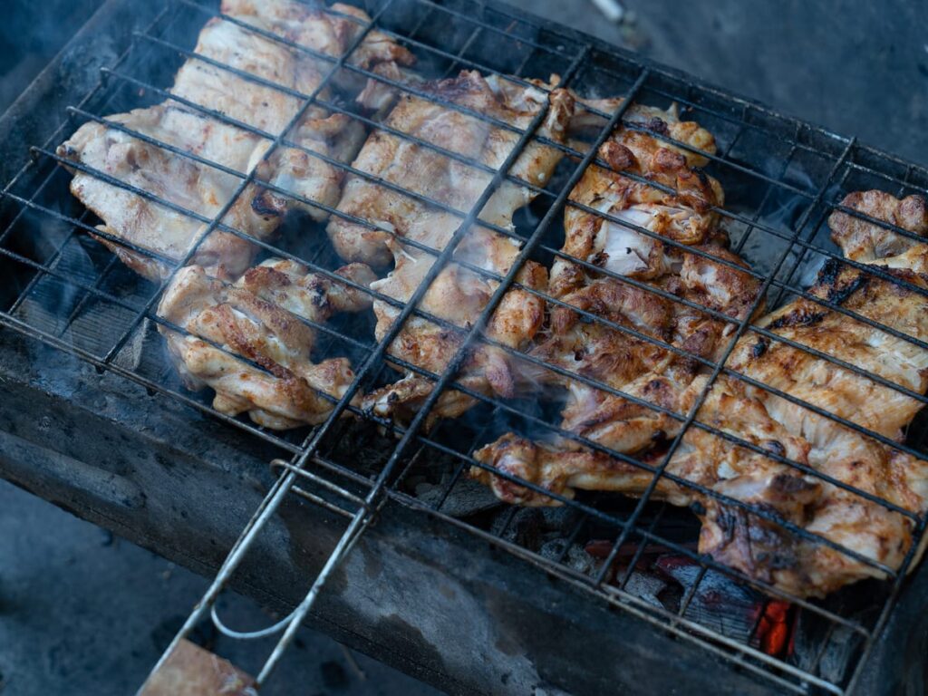 Gegrillte Hähnchenstücke auf einem kleinen Holzkohlegrill am Straßenrand in Istanbul