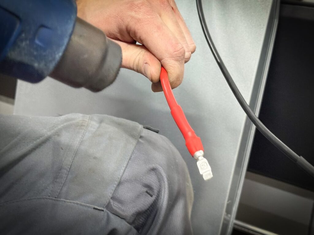 Rotes Stromkabel mit Schrumpfschlauch für die Verschweißtoilette im Camper