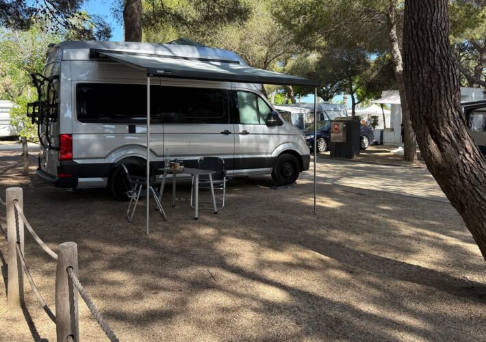 Wohnmobil auf schattigem Stellplatz im Tamarit Beach Resort an der Costa Dorada unter Pinien