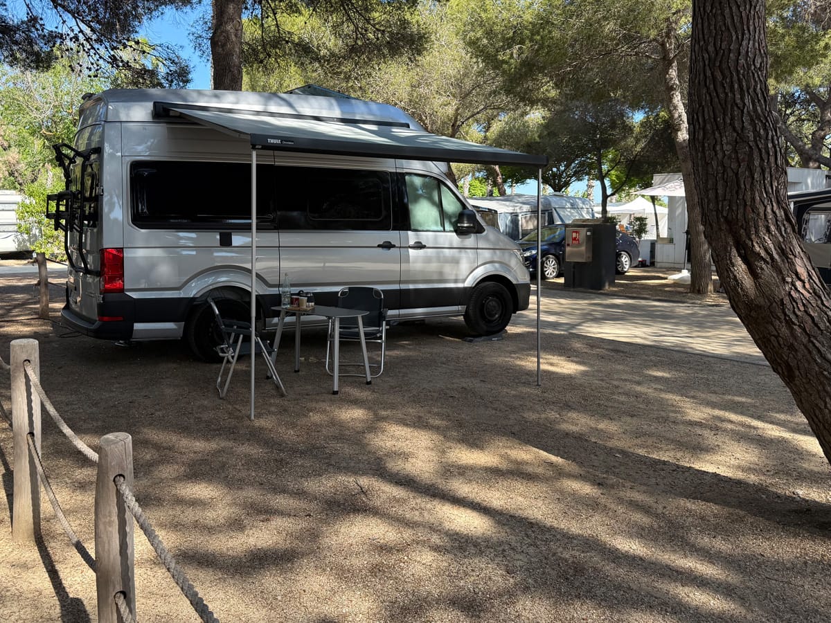 Wohnmobil auf schattigem Stellplatz im Tamarit Beach Resort an der Costa Dorada unter Pinien