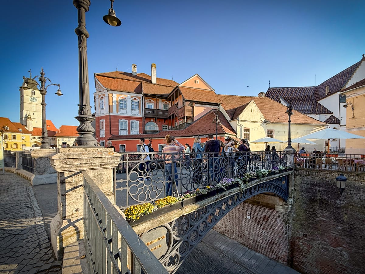 Menschen auf der Lügenbrücke in Sibiu mit Blick auf die Altstadt und historische Gebäude