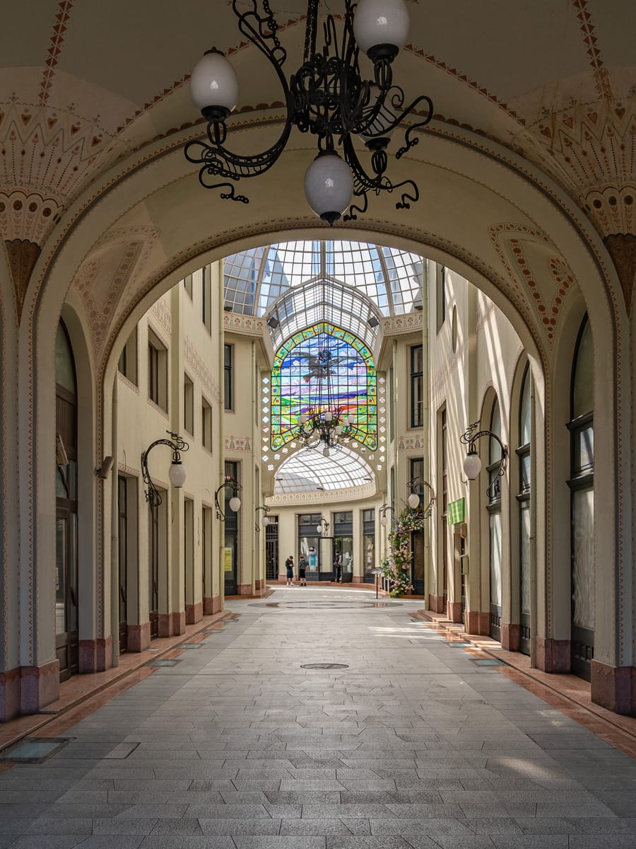 Innenansicht der Passage Schwarzer Adler in Oradea mit Glasdach und buntem Fenster