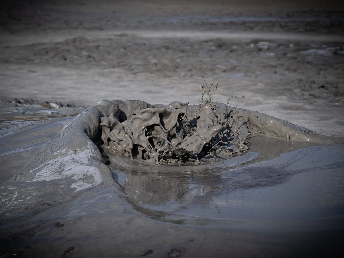Blubbernder Schlammvulkan bei Berca mit spritzender Schlammblase