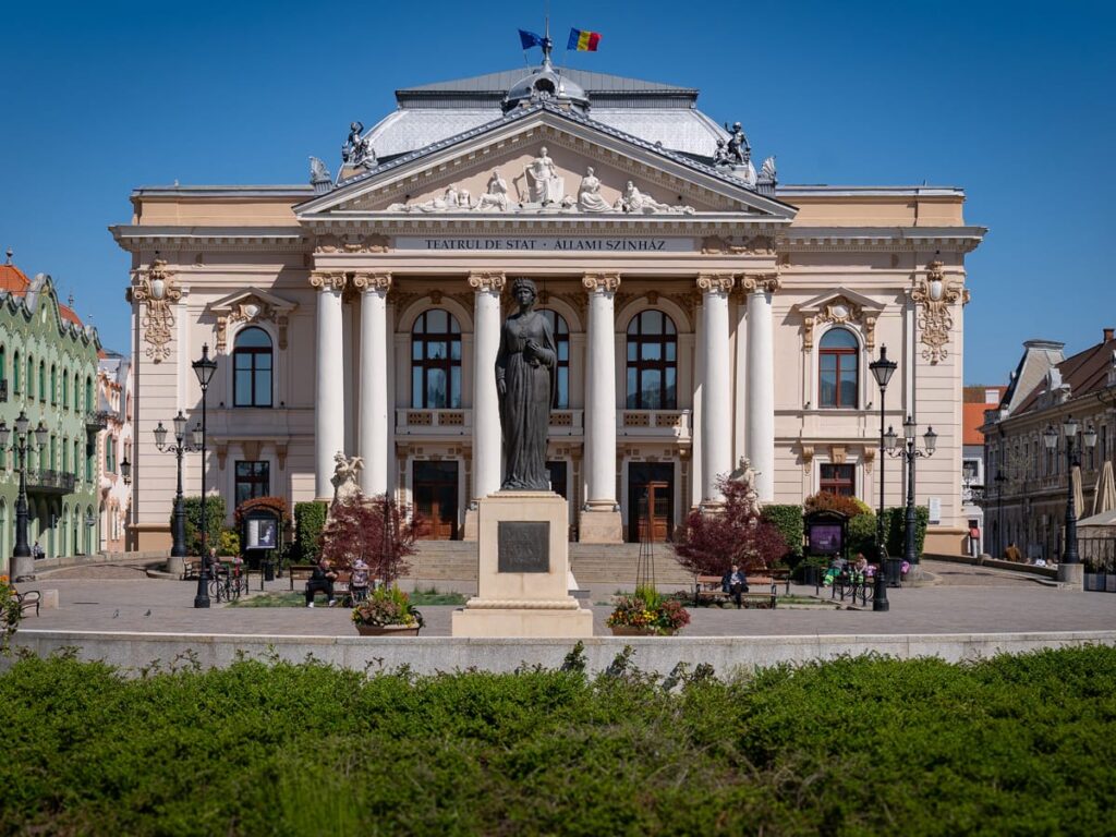 Fassade des Staatstheaters Oradea mit Säulen und Statue vor dem Gebäude