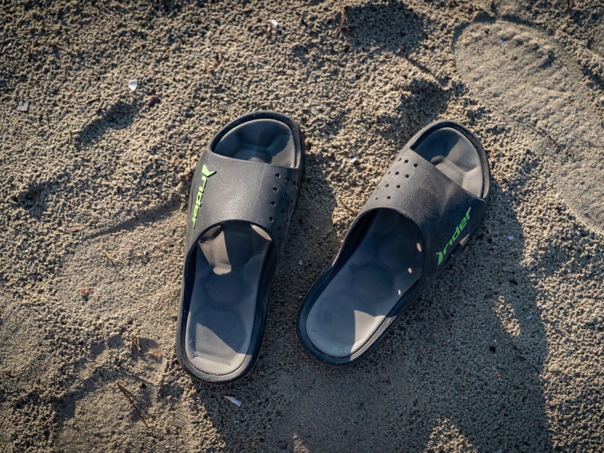 Badeschlappen im warmen Sand am Strand in Nordgriechenland