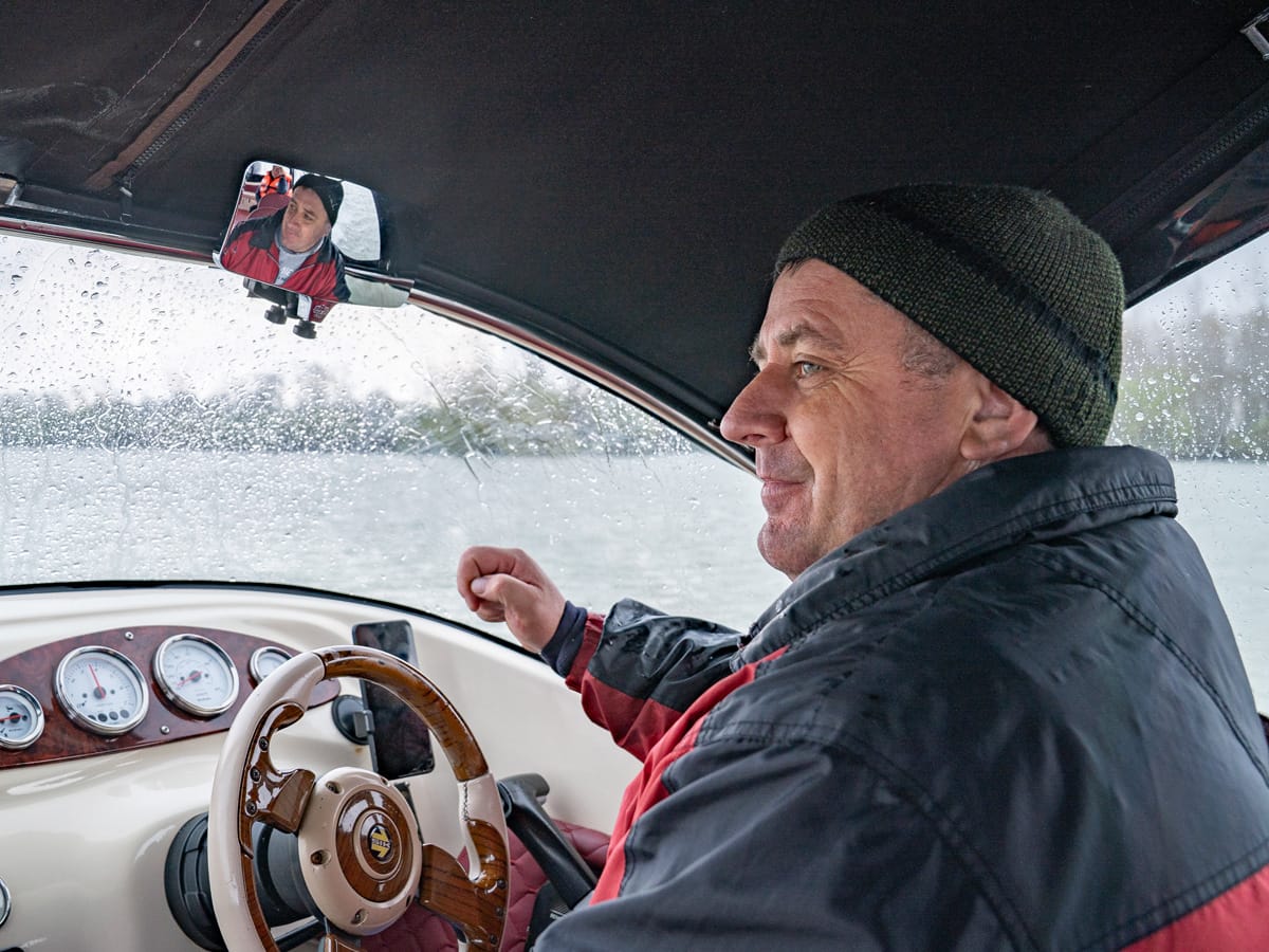 Steuermann eines Bootes bei Regen und Hagel im Donaudelta