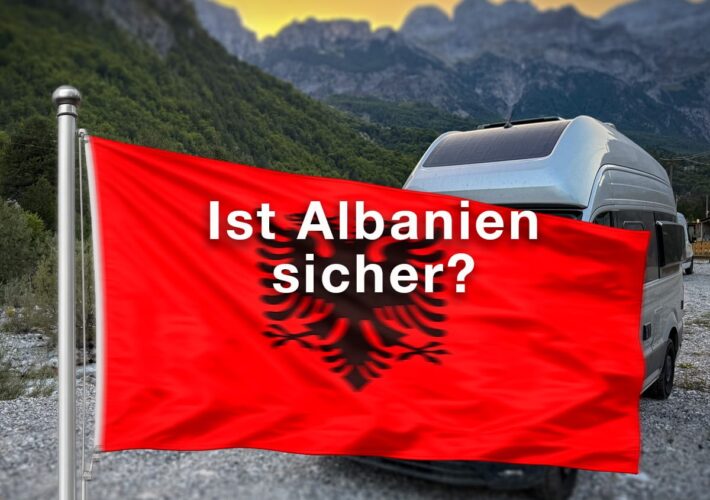 Albanien-Flagge vor Wohnmobil und Bergen in Theth mit der Frage „Ist Albanien sicher?“