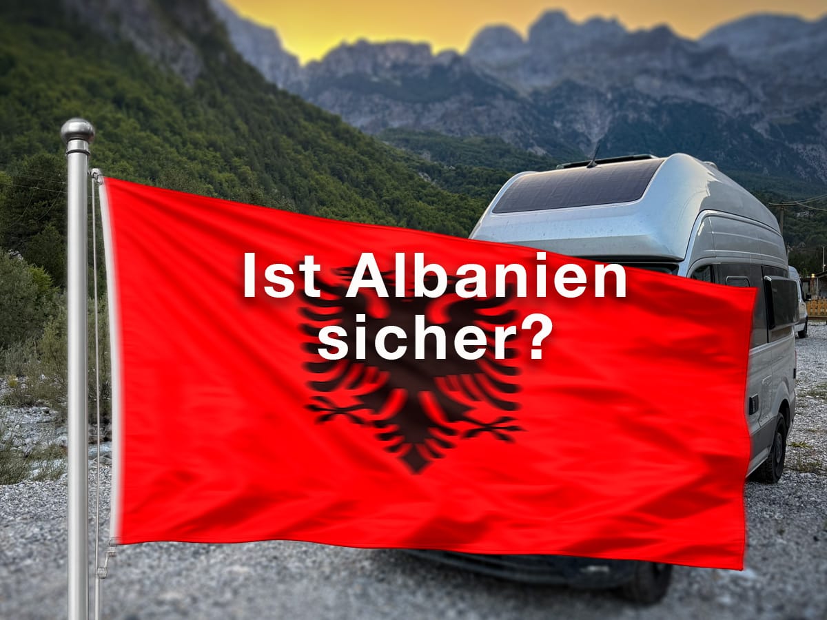 Albanien-Flagge vor Wohnmobil und Bergen in Theth mit der Frage „Ist Albanien sicher?“