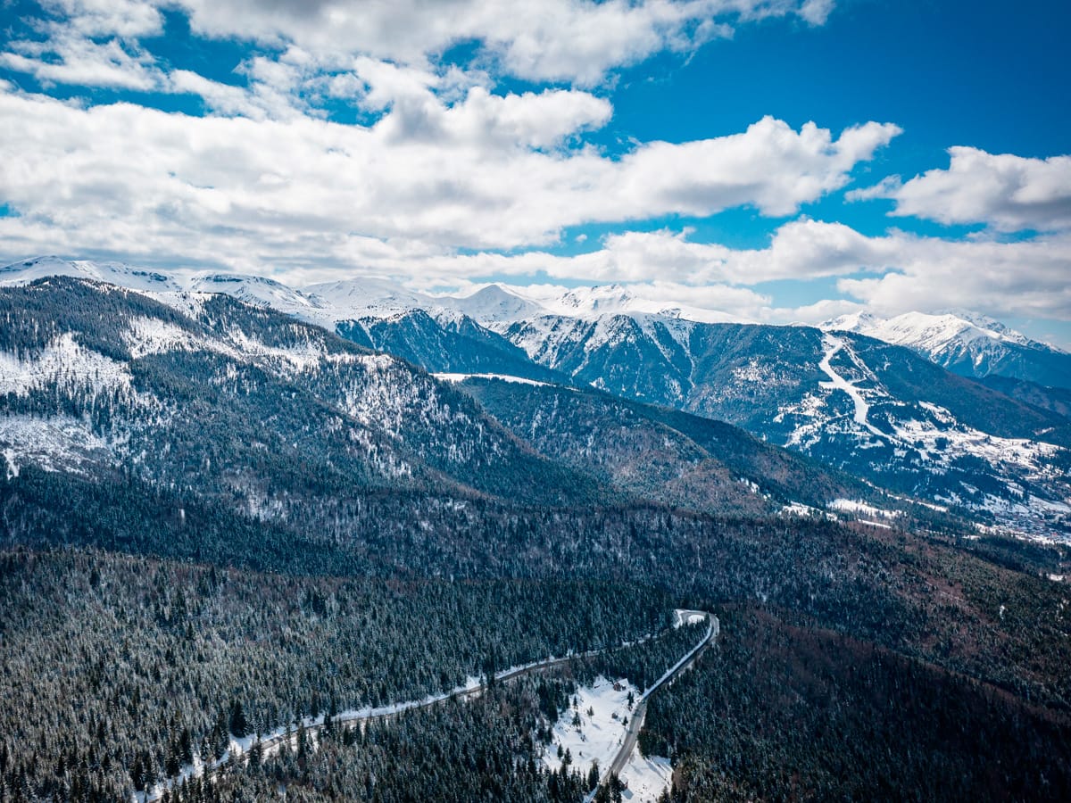 Rodna-Gebirge in den Karpaten mit verschneiten Gipfeln und Straße aus der Luft