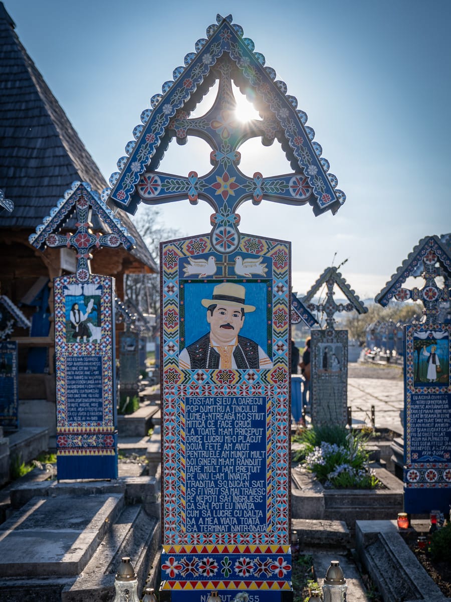 Bemaltes Holzkreuz im Gegenlicht auf dem fröhlichen Friedhof in Săpânța