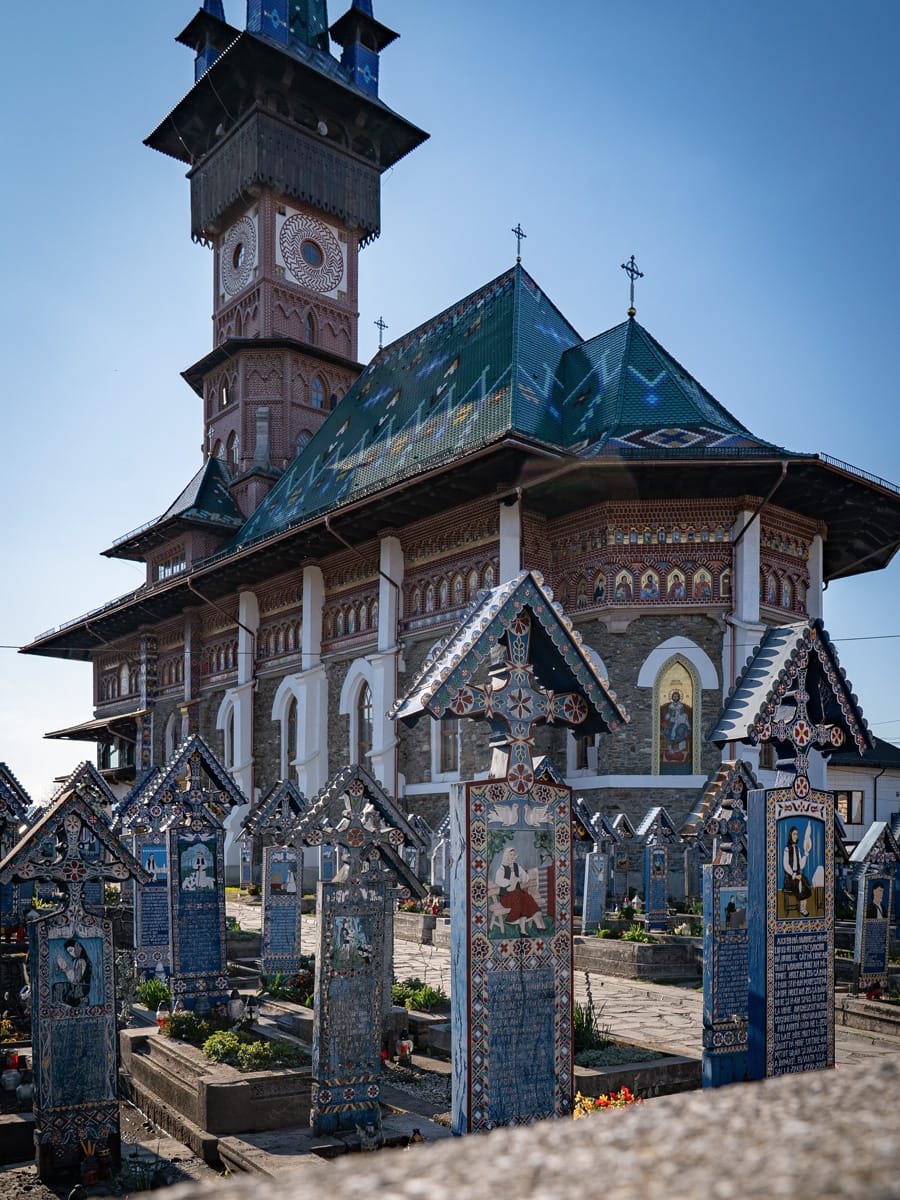 Bunte Holzkreuze vor der Kirche auf dem fröhlichen Friedhof in Săpânța in Rumänien