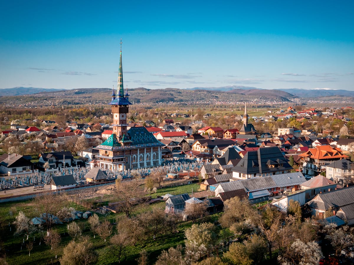 Luftaufnahme des fröhlichen Friedhofs mit der Kirche in Săpânța in der Region Maramureș in Rumänien