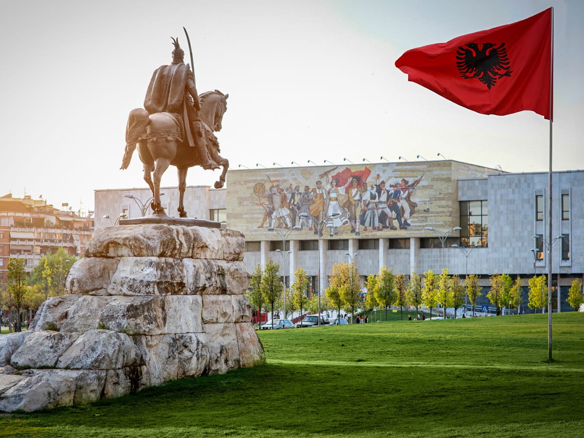 Skanderbeg-Denkmal auf dem Skanderbeg-Platz in Tirana mit albanischer Flagge