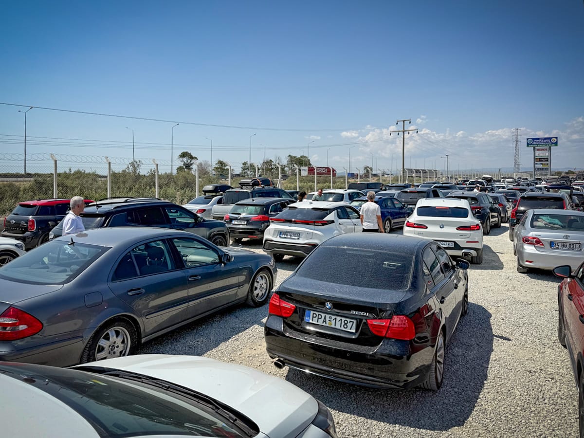 Fahrzeuge warten im Sommerstau auf dem Schotterplatz am Grenzübergang İpsala–Kipi zwischen Türkei und Griechenland