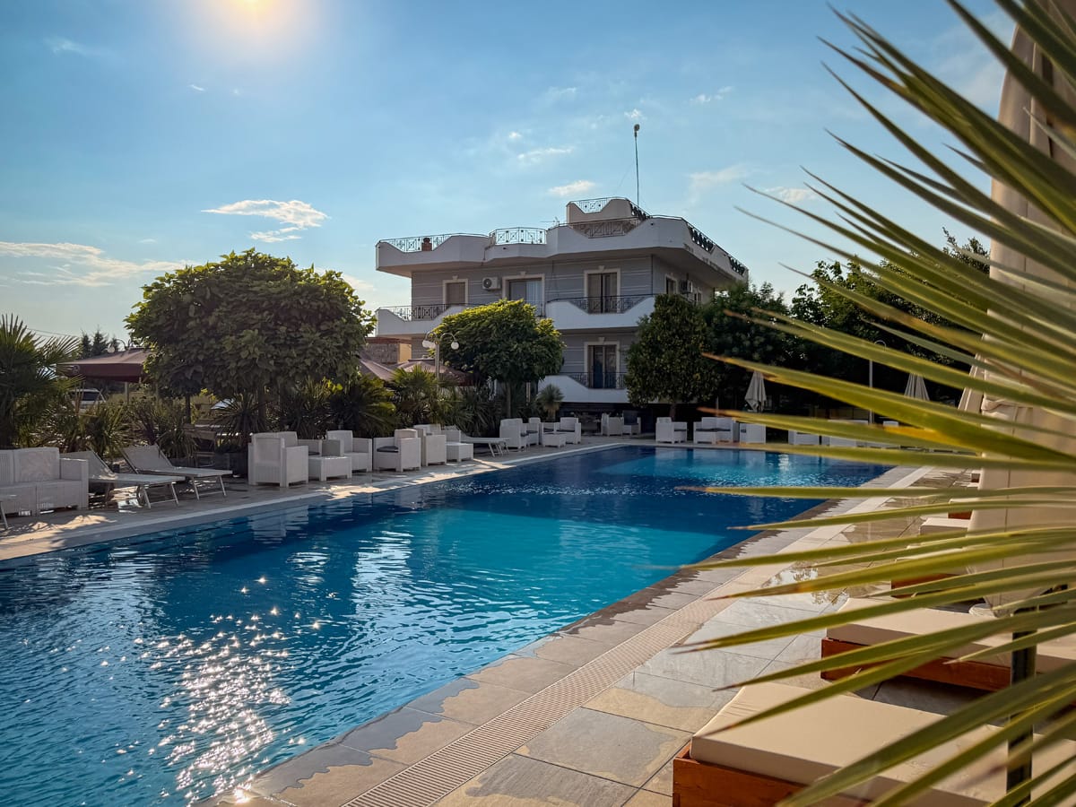 Poolbereich des Bar Restaurant Union in Postribë bei Shkodra mit Liegen und Hotelgebäude.