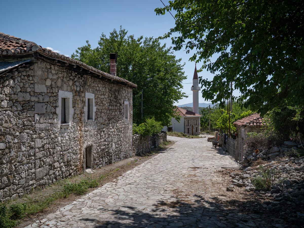 Historische Dorfstraße mit Natursteinhäusern und Moschee in Drisht innerhalb der ehemaligen Burganlage