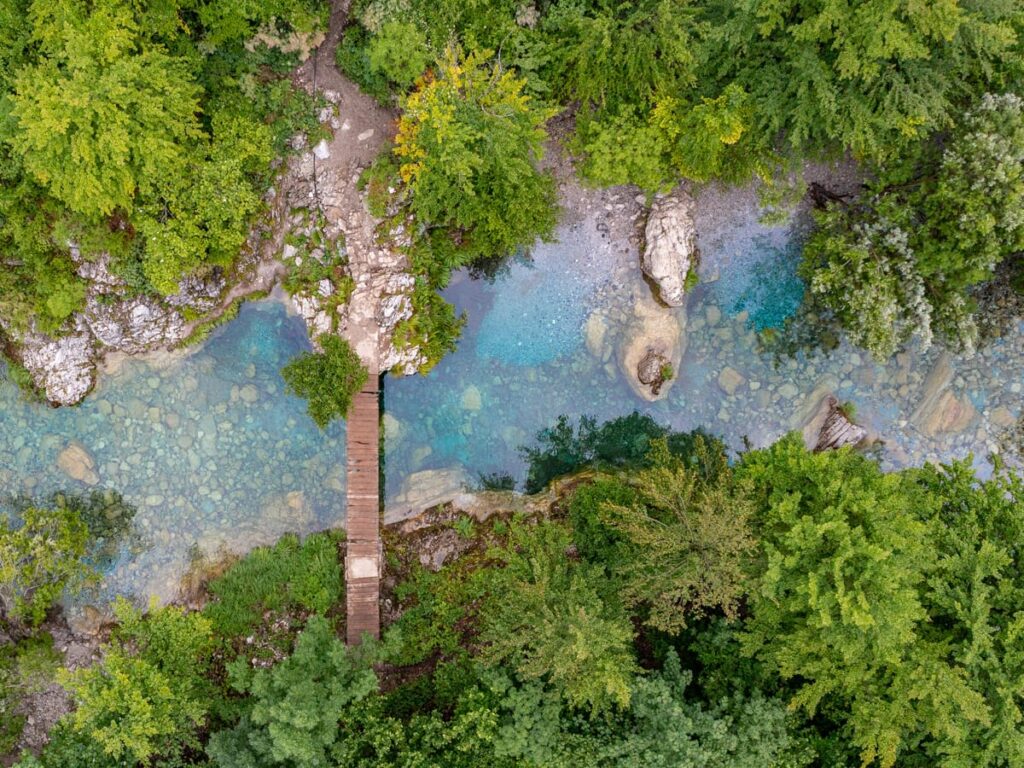 Drohnenaufnahme der Lagune und Holzbrücke kurz vor dem Blue Eye bei Nderlysaj in Albanien.