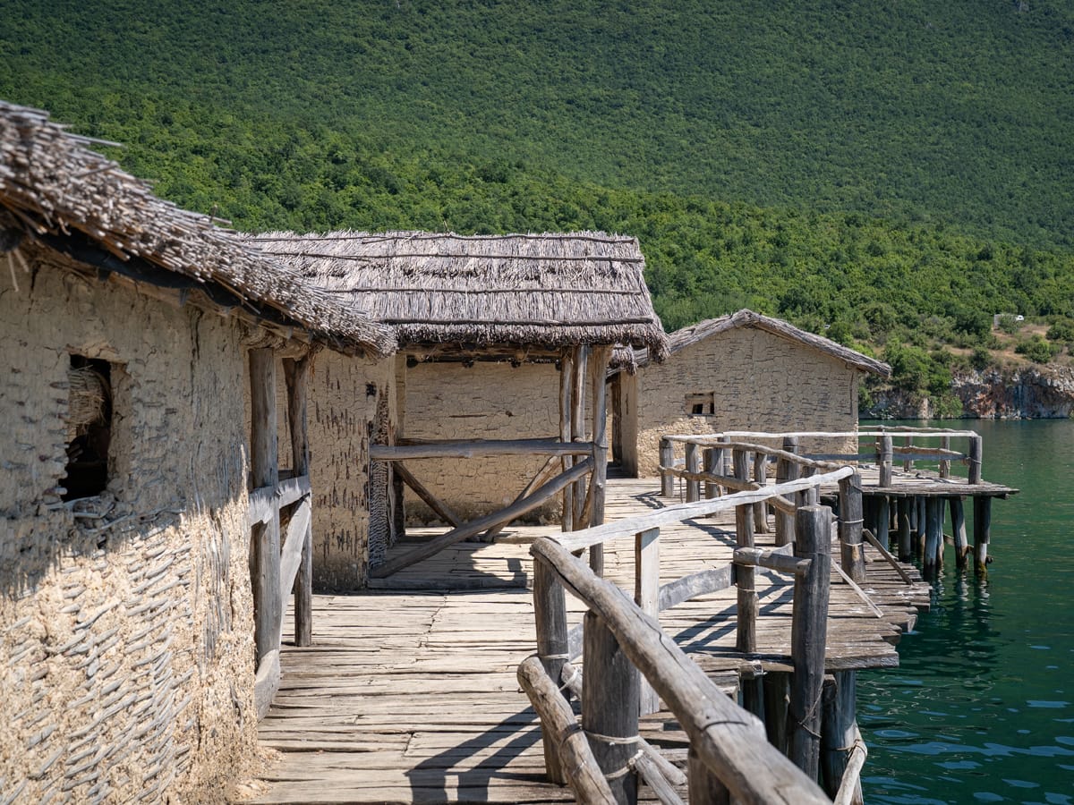 Holzstege und rekonstruierte Pfahlhäuser der Museumsbucht der Knochen am Ohridsee in Nordmazedonien.