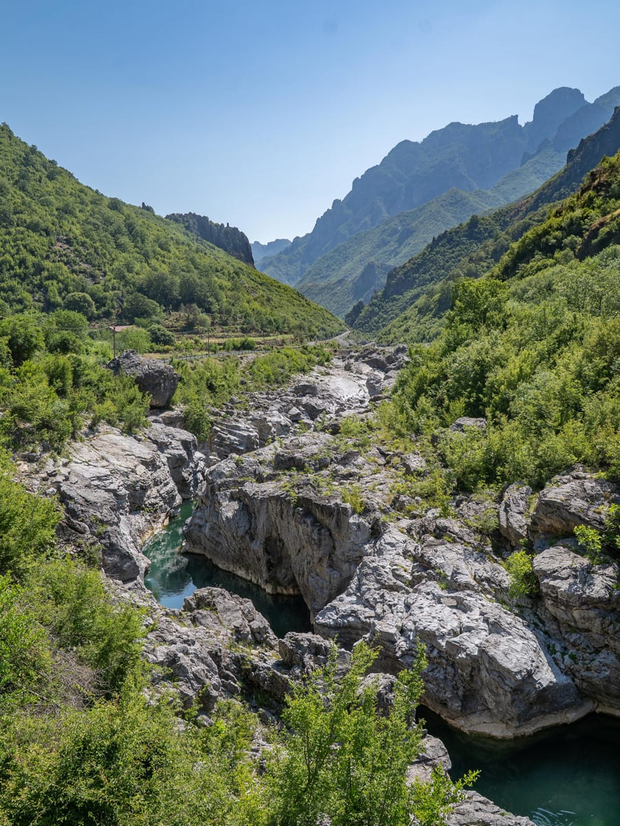 Blick über die Kalksteinschlucht des Kir-Flusses bei Prekal mit kristallklarem, smaragdgrünem Gebirgswasser und den Bergen Nordalbaniens im Hintergrund.