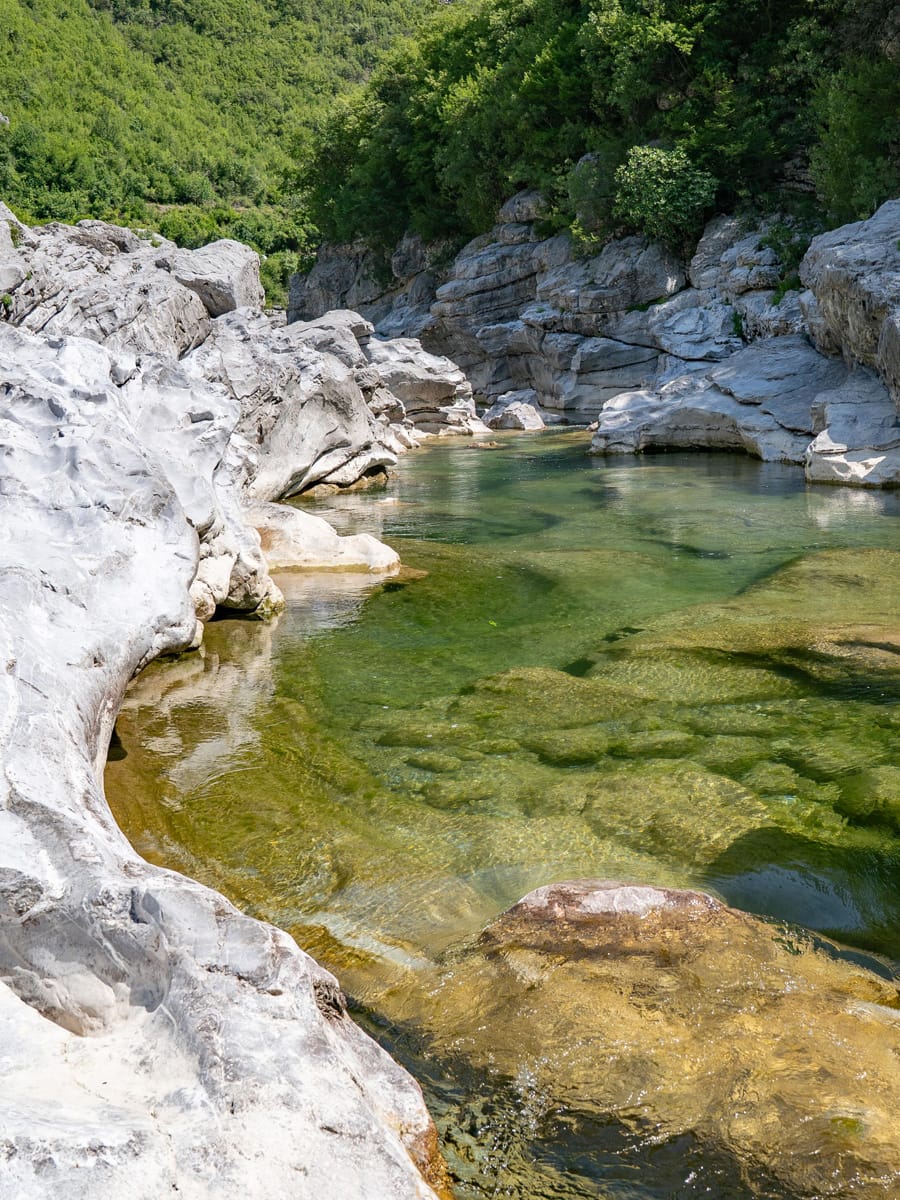 Kristallklarer Naturpool mit smaragdgrünem Gebirgswasser zwischen hellen Kalksteinfelsen am Kir-Fluss bei Prekal in Nordalbanien.