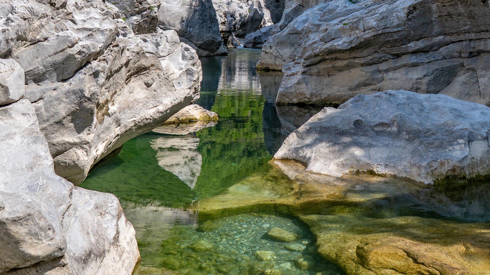 Kristallklarer Naturpool mit smaragdgrünem Gebirgswasser zwischen hellen Kalksteinfelsen am Kir-Fluss bei Prekal nahe Shkodra.