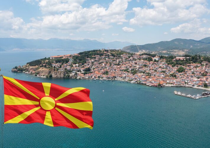 Drohnenaufnahme der Altstadt von Ohrid am Ohridsee mit der Flagge Nordmazedoniens im Vordergrund.