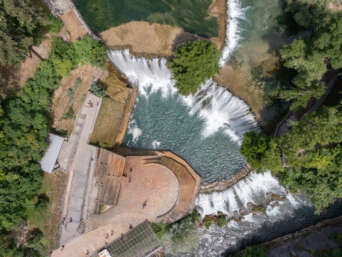 Luftaufnahme des Pliva-Wasserfalls in Jajce mit halbmondförmiger Felskante