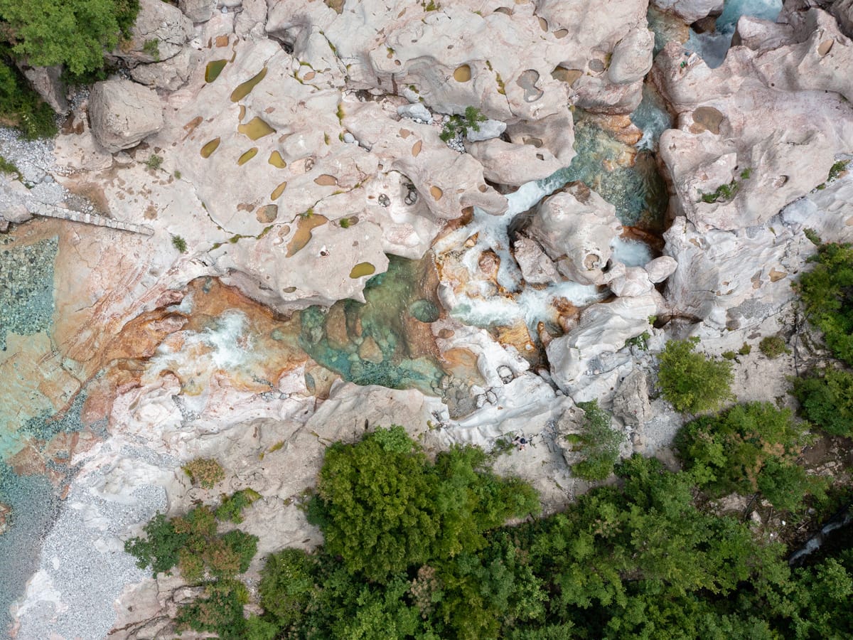 Drohnenaufnahme der Stone Groves of Nderlysa mit ausgewaschenen Kalksteinformationen und türkisfarbenem Wasser in den Albanischen Alpen