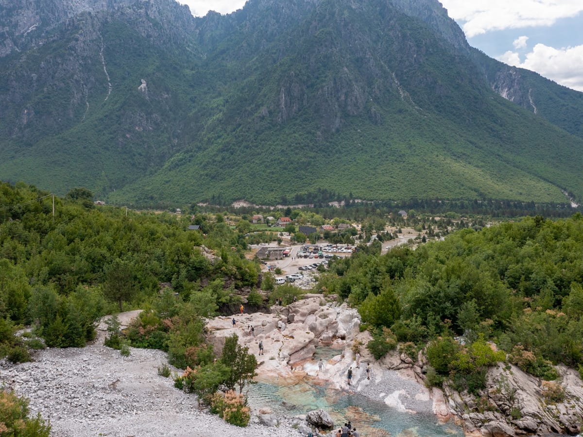 Stone Groves of Nderlysa mit türkisfarbenen Wasserbecken, Parkplatz und Bergkulisse der Albanischen Alpen