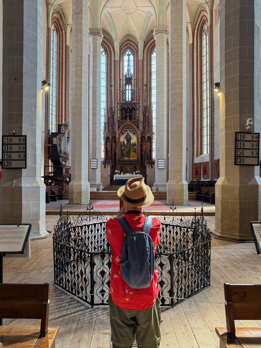 Blick durch den gotischen Innenraum der Schwarzen Kirche in Kronstadt. Ein Besucher fotografiert den Altar der ehemaligen Hauptkirche der Siebenbürger Sachsen.