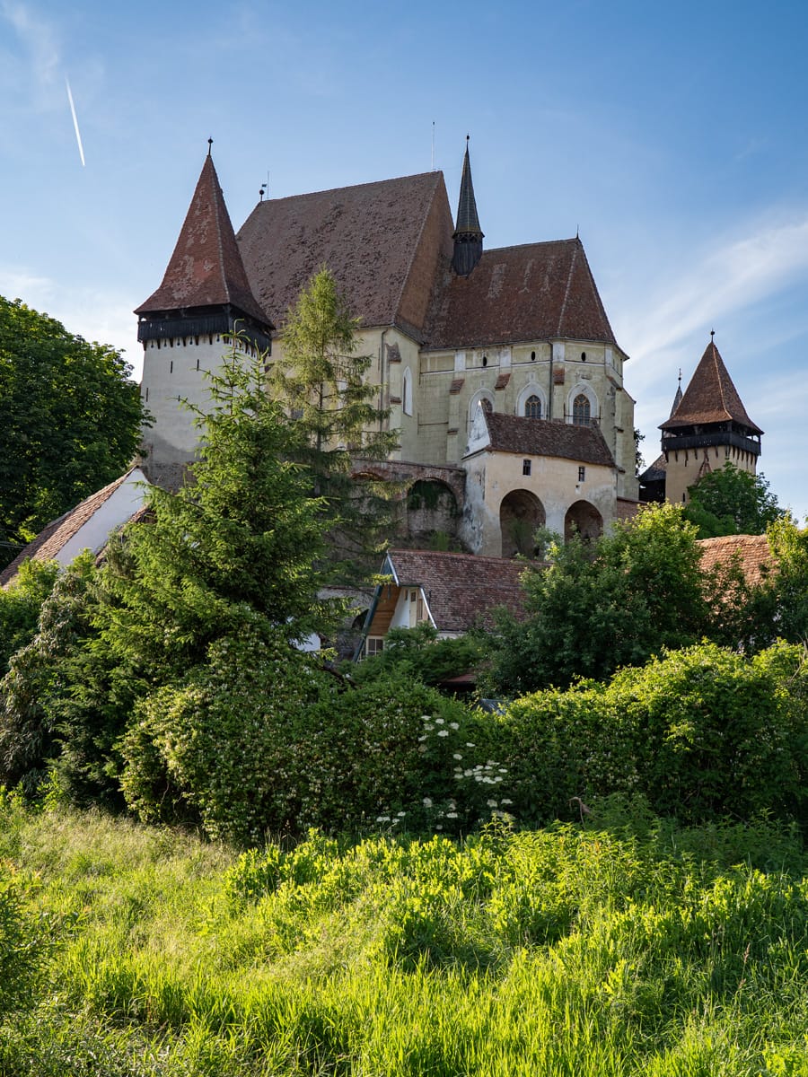 Blick auf die Kirchenburg Biertan (Birthälm) in Siebenbürgen, die sich über den historischen Häusern des Dorfes erhebt.