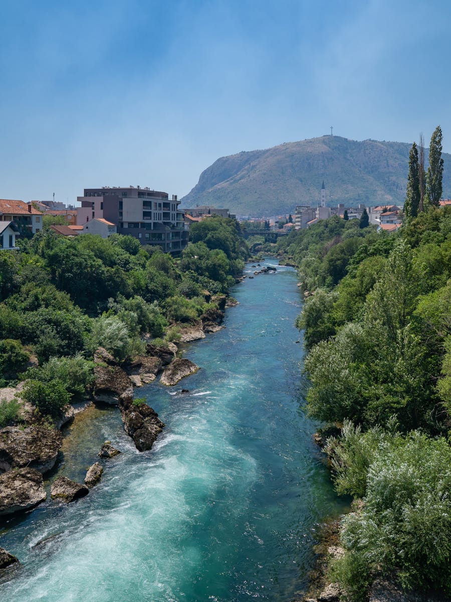 Türkisfarbene Neretva in Mostar mit Bergen im Hintergrund