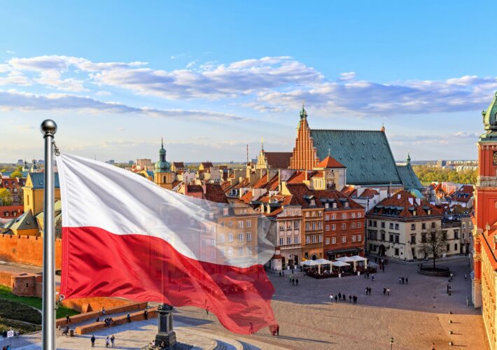 Blick über die Altstadt von Warschau mit polnischer Flagge im Vordergrund