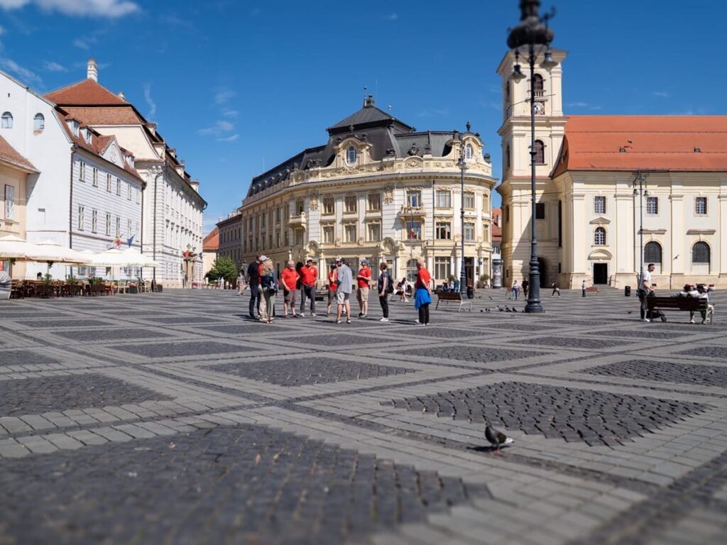 Stadtführer Christian erklärt einer Reisegruppe den Großen Ring in Hermannstadt (Sibiu) in Siebenbürgen.