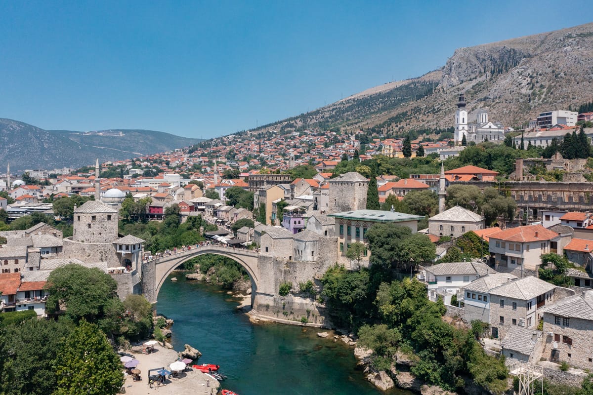 Stari Most über der Neretva mit der Altstadt von Mostar und den Bergen im Hintergrund